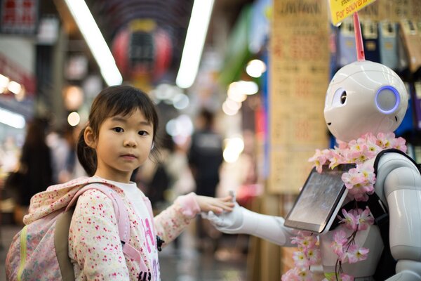A girl holding hands with an artificially intelligent robot.